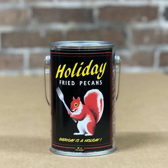 Holiday Fried Pecans tin with red squirrel illustration on a wood tabletop