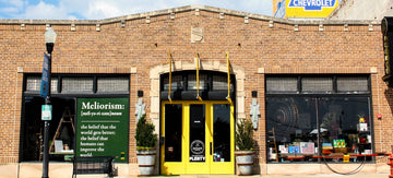 Brick building with yellow doors and Scott Chevrolet sign under a blue sky.